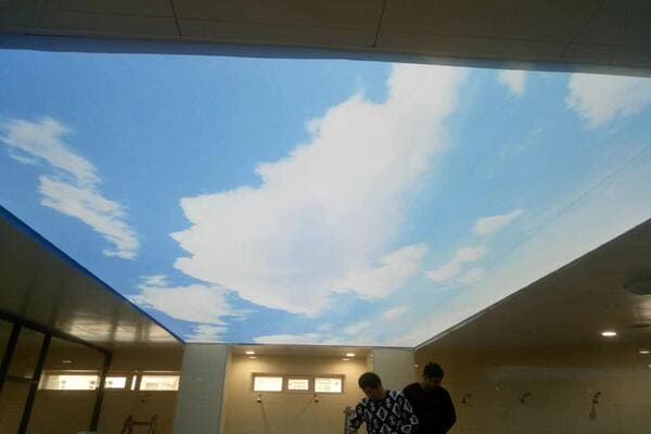A designer showing a customer a high-resolution sky rendering for a stretch ceiling sky project